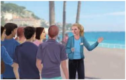 Une guide parle à un groupe de touristes devant la mer.